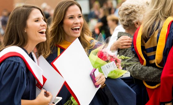 Two twin female graduate students at convocation
