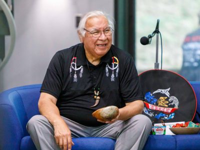 Elder smiles while holding an abalone shell.