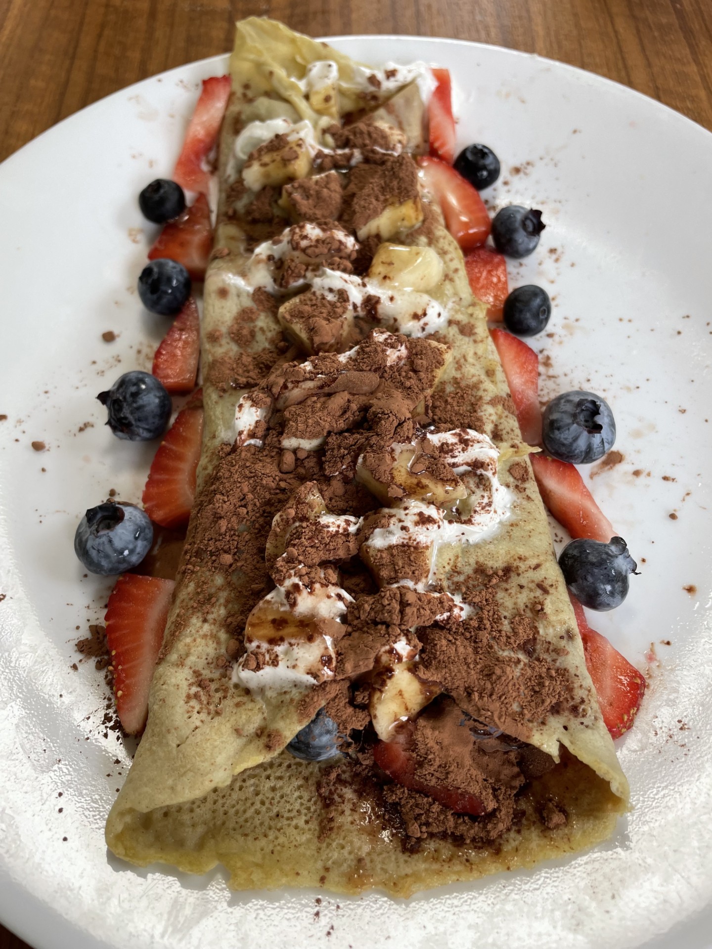 Picture of a filled crepe with fruit and cinnamon powder 