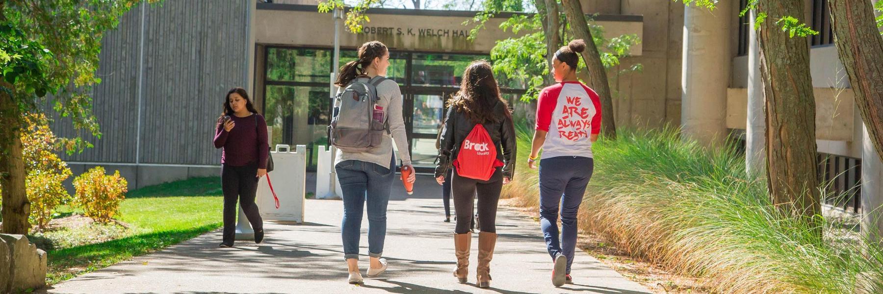 Brock University autumn students walking to Welch Hall