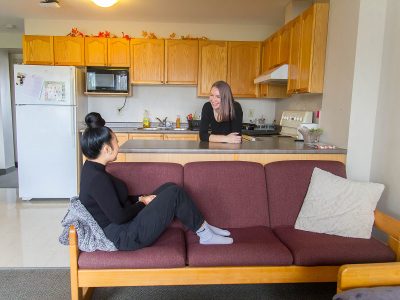 A student in the kitchen and another on the couch in Quarry View
