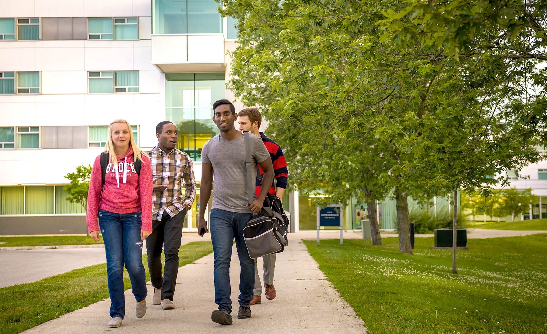 Four students walking outside of Lowenberger residence