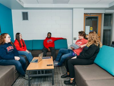 Residence 8 lounge with 5 students talking together