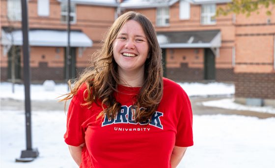 a student stands in the courtyard of village residence