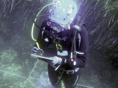 scuba diver writing on tablet underwater