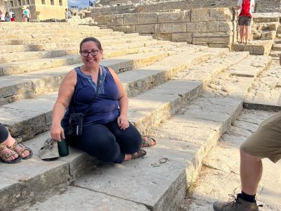 professor sitting on the steps of the Theatral Area at Knossos
