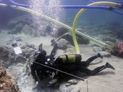 2 scuba divers documenting area underwater