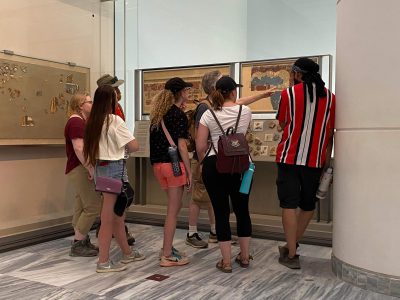 7 students an professor look at ancient map At the Heraklion Museum