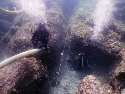 2 scuba divers documenting area underwater