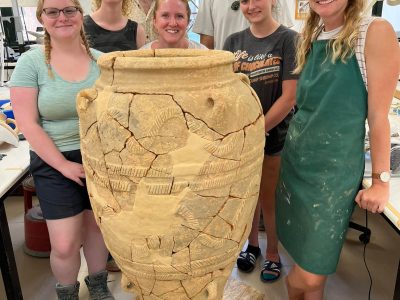 Students posing with Angela and the pithos (large storage jar) they helped to reconstruct