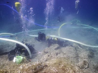 3 scuba divers documenting area underwater