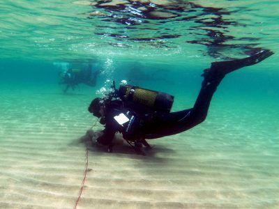 scuba diver on the lake bed holding a rope