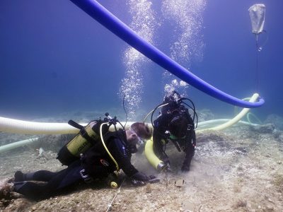 2 scuba divers documenting area underwater