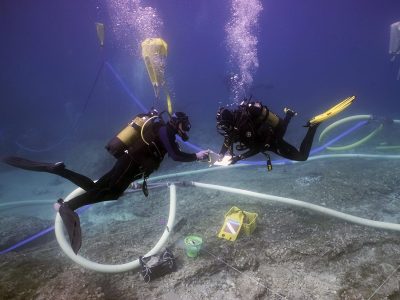 2 scuba divers documenting area underwater