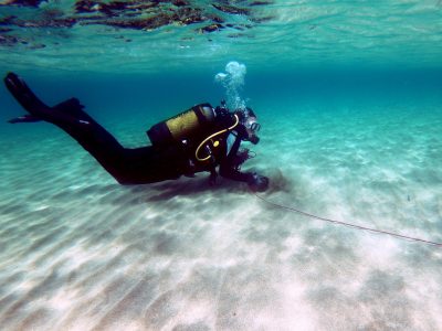 scuba diver on the lake bed holding a rope