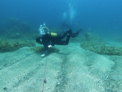 scuba diver on the lake bed holding a rope