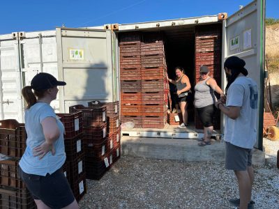 internal view of a truck stacked with crates and 4 students opening the door