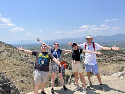 Study Tour of Greece 4 students with arms extended in excitement in front of mountains