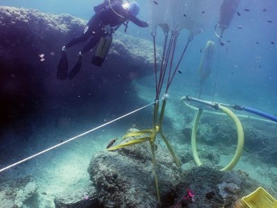 scuba diver with underwater balloon lifting stone