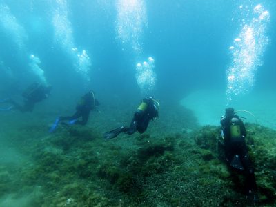 4 scuba divers on the lake bed