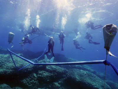 8 scuba divers lifting an artifact underwater balloons
