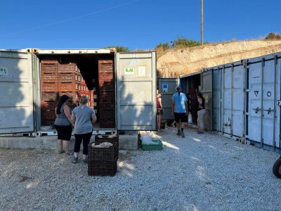 6 student s looking inside shipping containers and pulling crates out