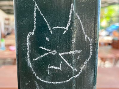 at face drawn in chalk on a black steel pole in Gournia