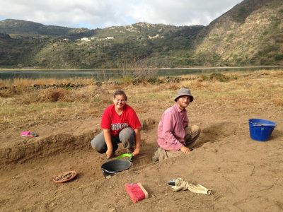 2 students in a archeology field outside mountains