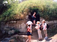 The group enters an Etruscan tumulus tomb at Cerveteri