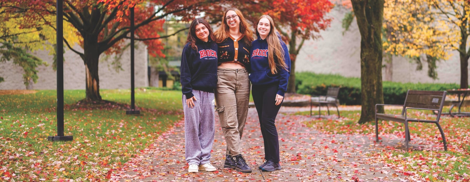 3 smiling students on Brock University campus