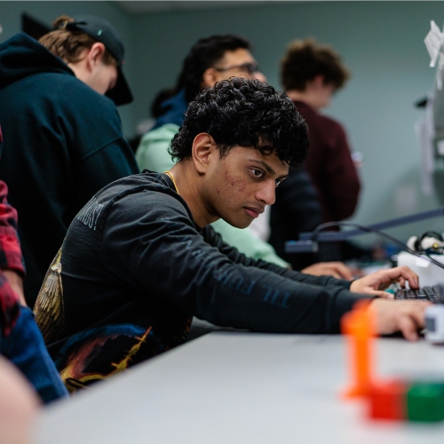 University of Portsmouth logo and computer science student working on robotics