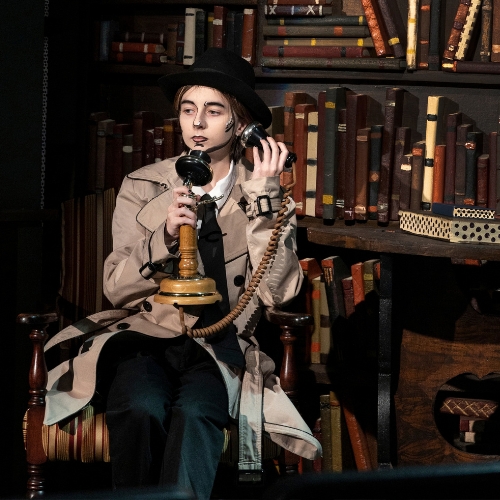 Dramatic arts student dressed in 1930's outfit with old telephone
