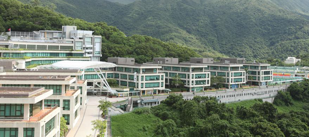 Modern glass buildings line the a green mountainside at Education University of Hong Kong.