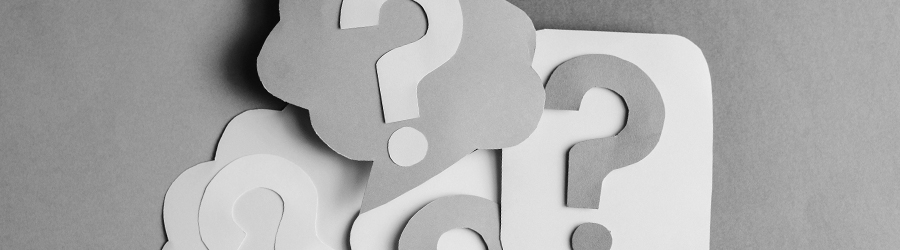 Paper cut-outs of question marks stacked on top of one another.