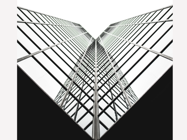 Image of a skyscraper in glass and steel from the vantage point directly below the building and looking up.