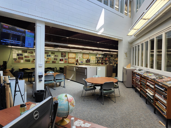 The Map, Data & GIS Library space features group seating and cozy spots with light streaming in from skylights.