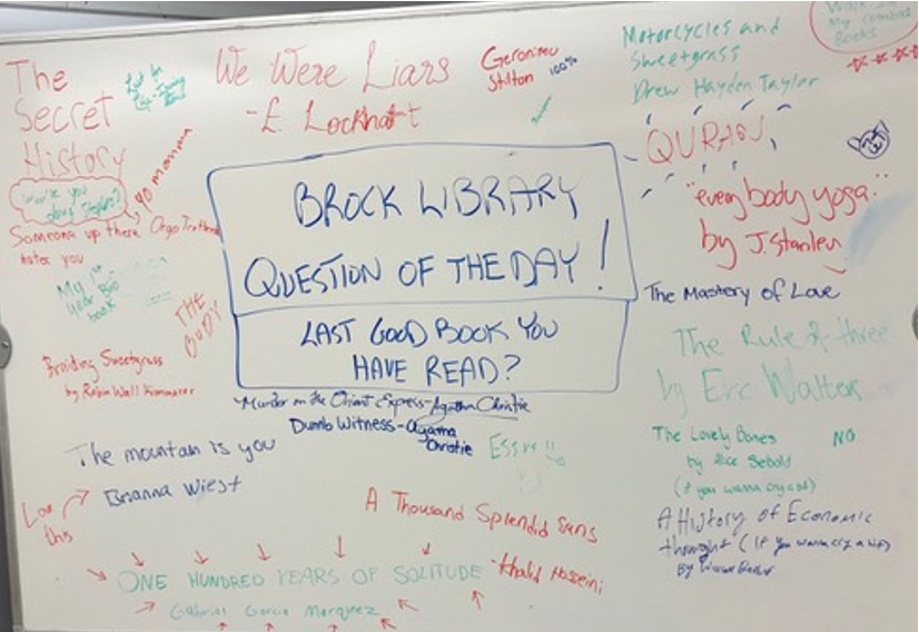 titles of books hand written on large whiteboard
