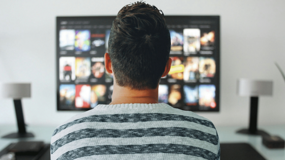 Image of a man viewing streaming video options on a TV