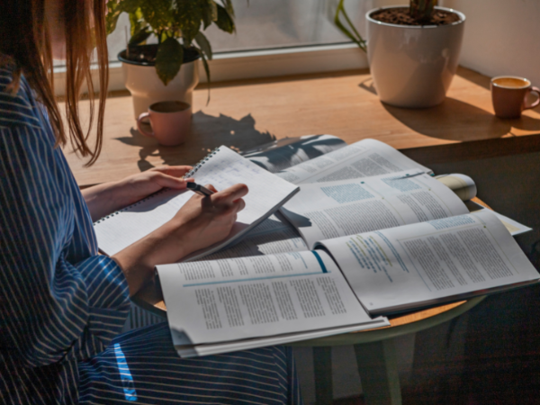 woman working at a desk with papers and articles