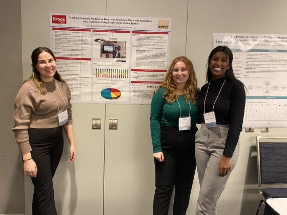 Lab students standing in front of research poster.