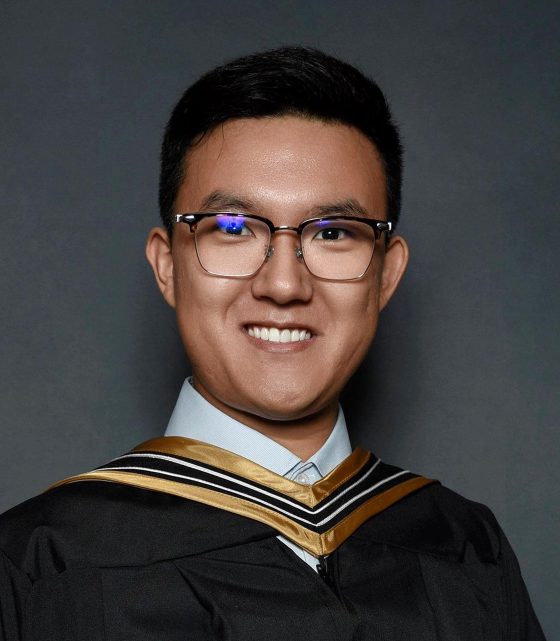 Yuxin Ding posing in academic robe