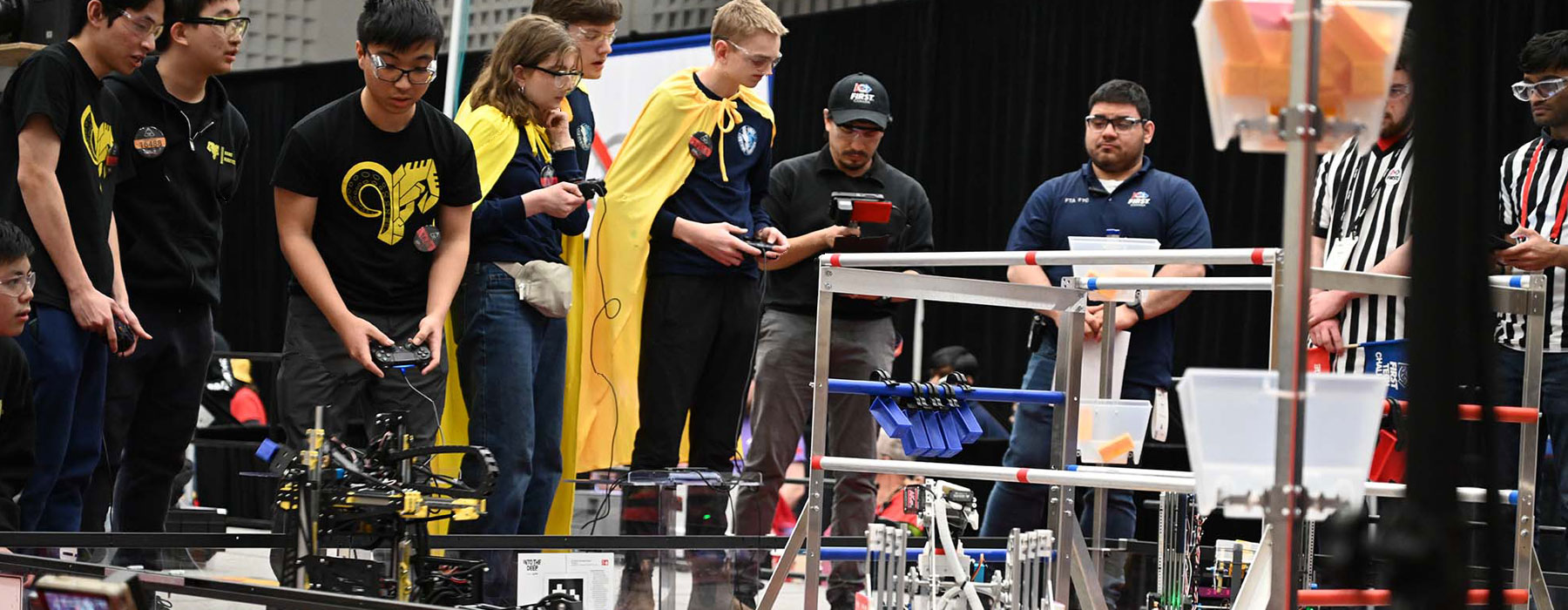 Robotics competition field with students and robots piloting their robot