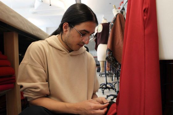 A person works on a costume in a wardrobe studio.