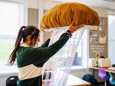 Dramatic arts student Nav Brar works on a mushroom costume in the Costume Shop.