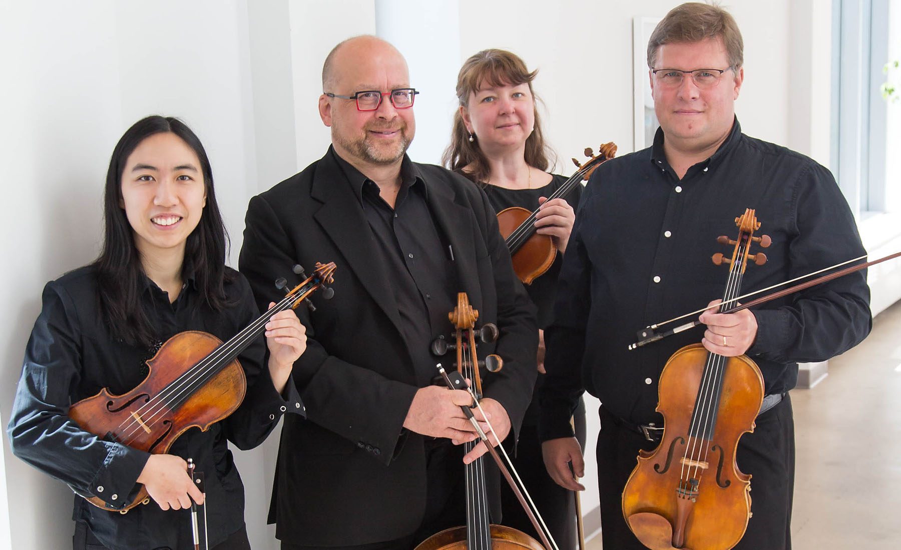 Walker String Quartet holding instruments in hallway