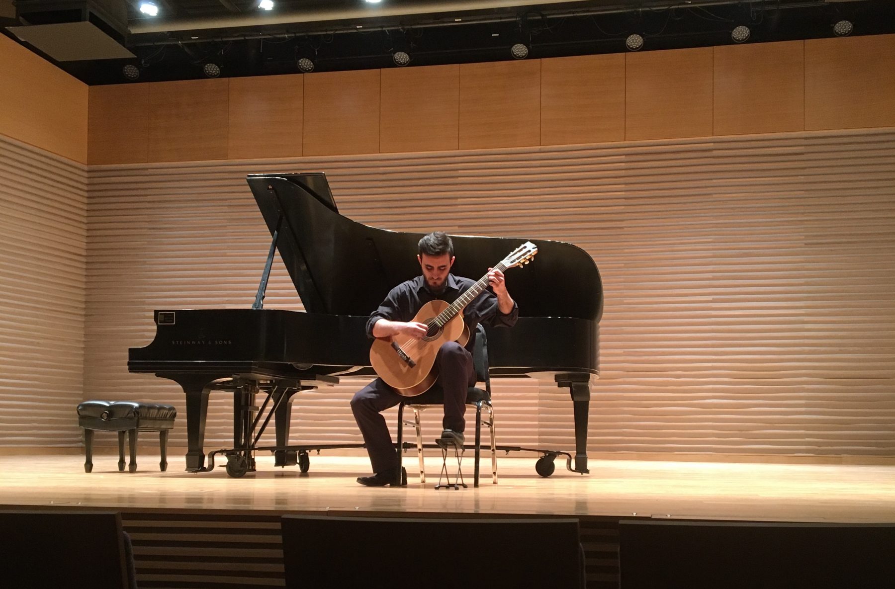 Brock Music student is on stage playing guitar.