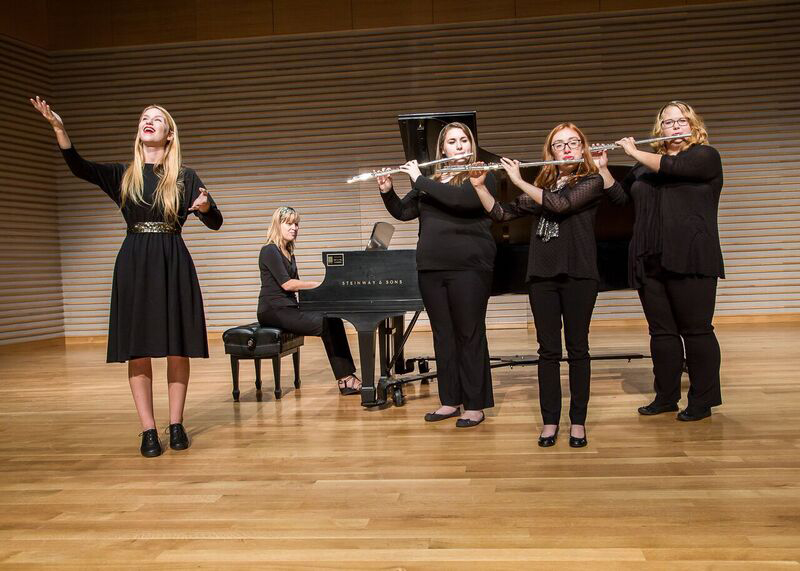 musicians playing flutes and a piano player while a woman sings