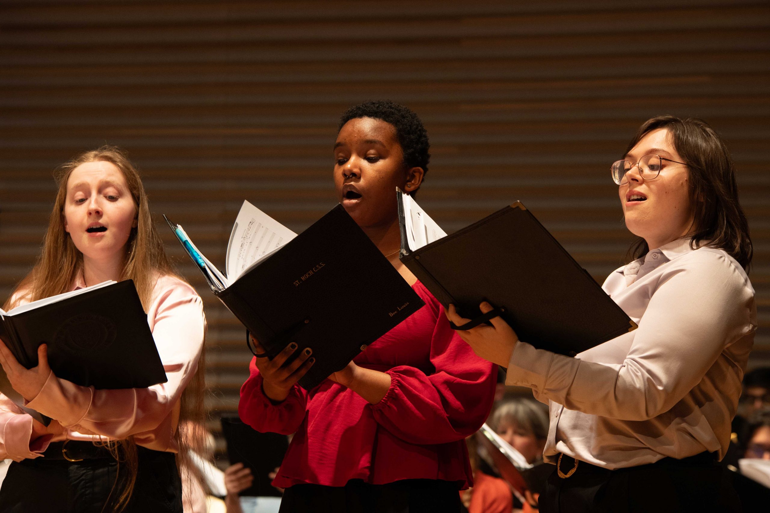 Performers in the Brock University Choir sing together on stage.