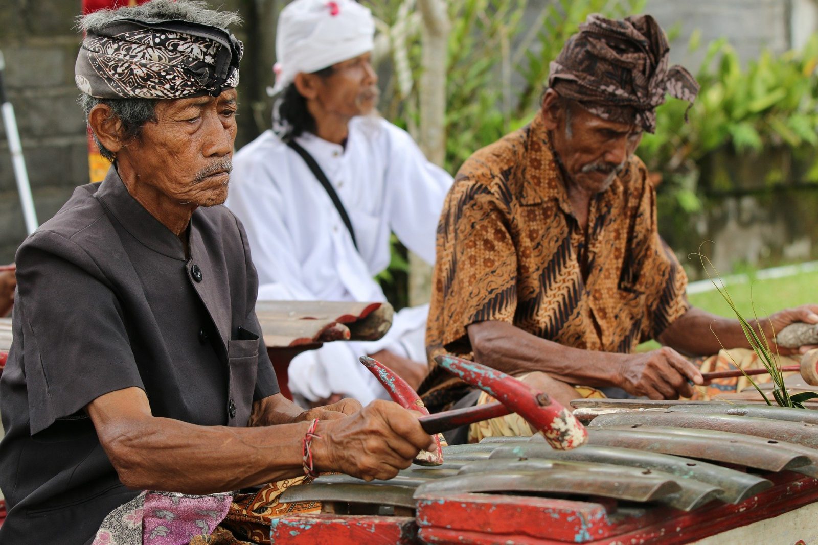 3 musicians palying on metal instrument in bali