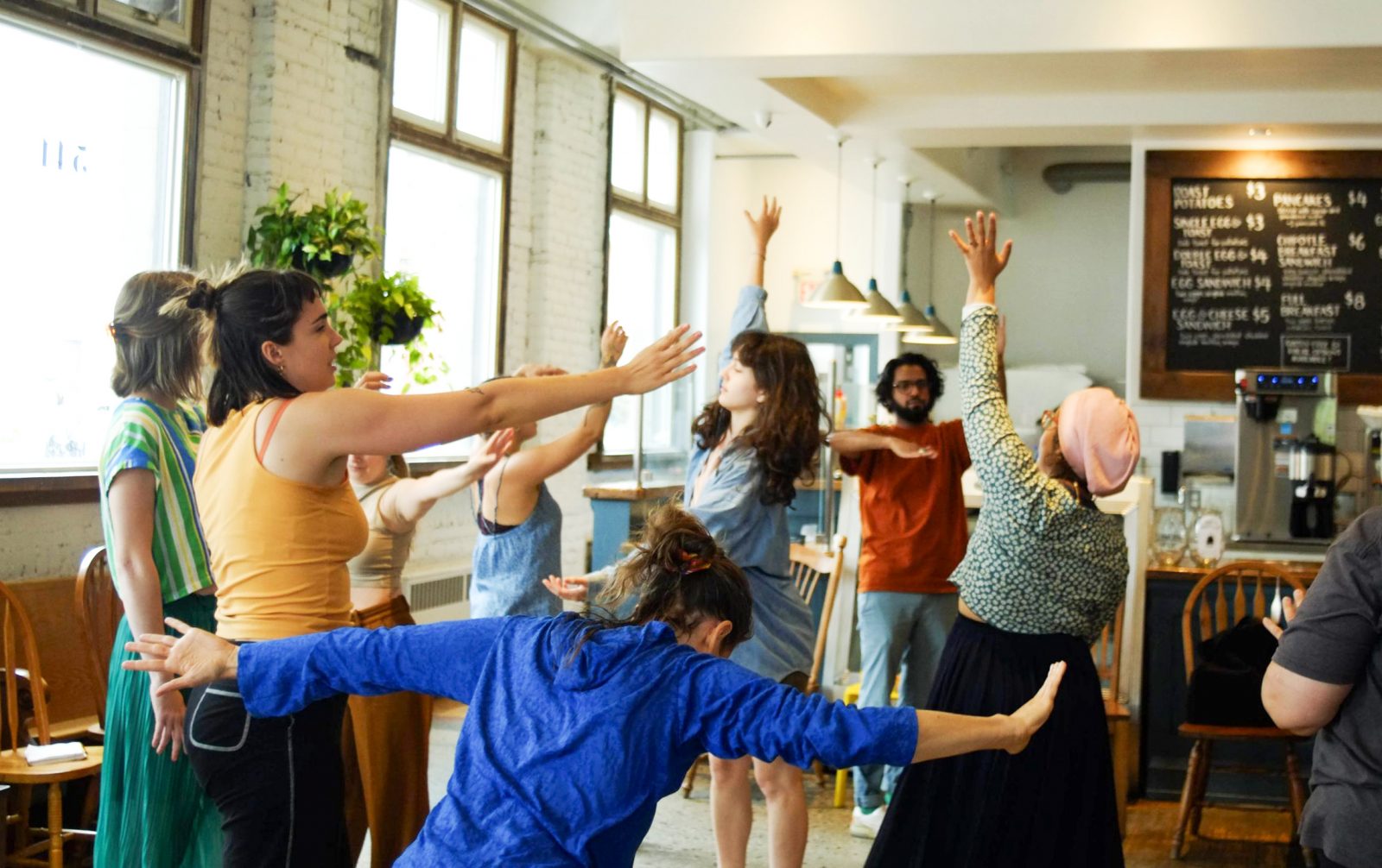 Participants move creatively in a bright theatre space .